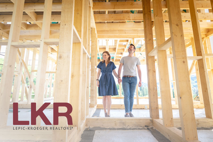 Image of a couple walking through a home being built with the LKR logo